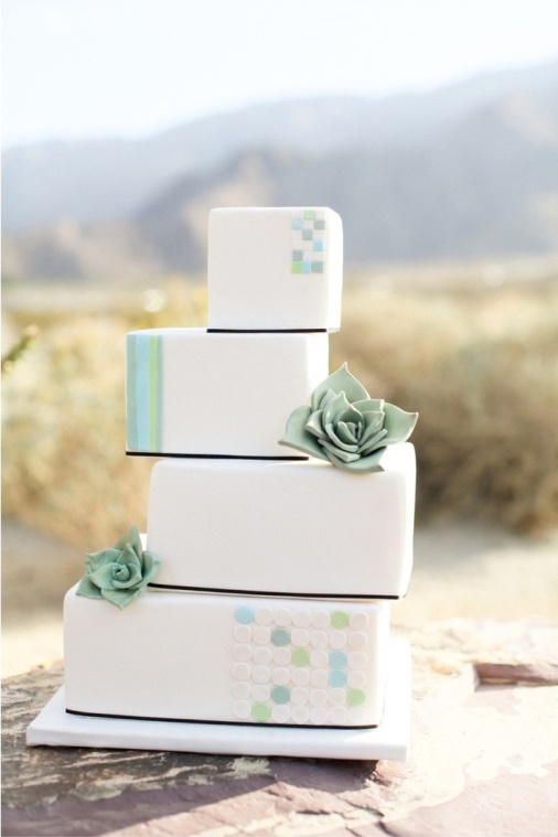 a stacked square wedding cake decorated with colorful dots and stripes plus sugar succulents is a lovely and fresh idea for a desert wedding