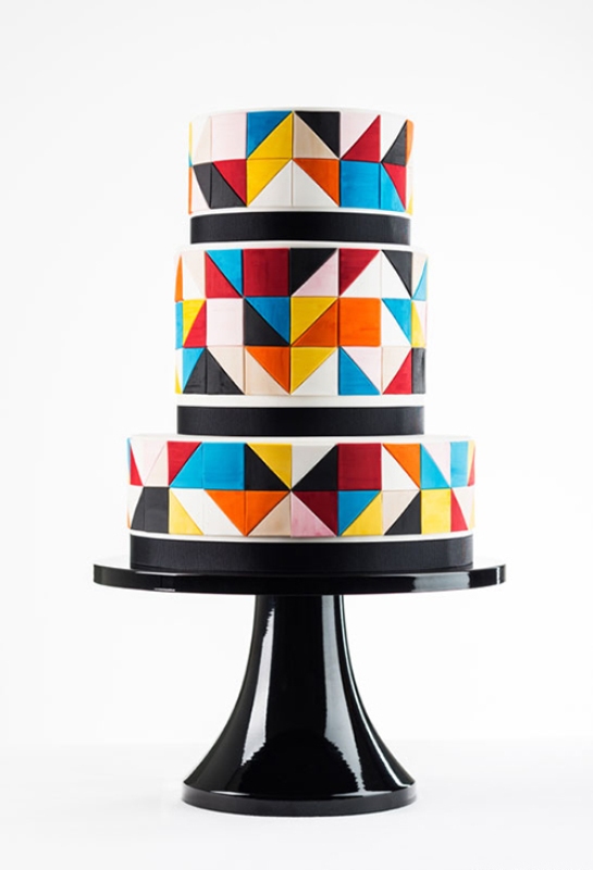 A round wedding cake with super colorful triangles covering it and black lines to highlight each tier is a lovely idea for a bold wedding