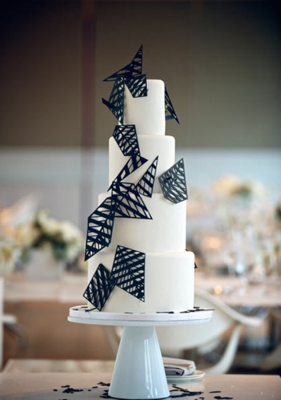 A white round wedding cake decorated with 3D black triangles and rhombs is a very stylish and cool idea