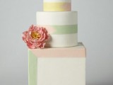 a pretty wedding cake with round and a square tier, with colorful lines and a design that highlights the square shape of the cake