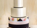 a round wedding cake with black lines, with a bold pink, gold and black triangle tier and a matching geometric heart topper is pure fun and chic