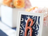 a printed navy and white table number and a coral number itself to highlight the color scheme you’ve chosen