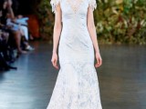a fitting lace wedding dress with a lace illusion neckline, short embellished sleeves and a train