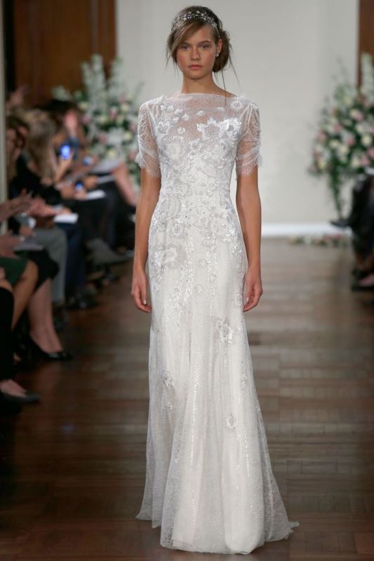 A lace embellished A line wedding dress with an illusion neckline and short sleeves for a bride who wants a romantic shining look