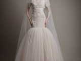 a whimsical lace mermaid wedding dress with a full tulle skirt, a high neckline, short sleeves and a veil
