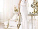 a fitting plain wedding dress with a V-neckline, short lace sleeves, an embellished sash and a train