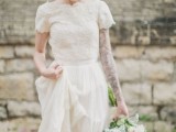 a lace A-line wedding dress with a lace bodice, short sleeves, a high neckline and a pleated maxi skirt