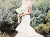 a whimsy mermaid lace wedding dress with a high illusion neckline, short sleeves, a ruffle layered skirt and a short train