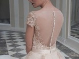 a nude lace wedding ballgown with a lace bodice, an illusion back on buttons and a full skirt with appliques