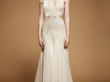 an embellished A-line art decor wedding dress with a deep neckline, cap sleeves and a small train