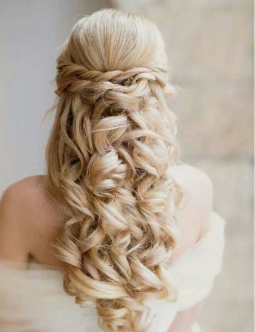 a romantic vintage wedding half updo with a volume on top, a braided halo and waves down is a gorgeous idea
