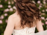 a romantic wedding half updo with a braid on one side and a twist on the second side, with waves down