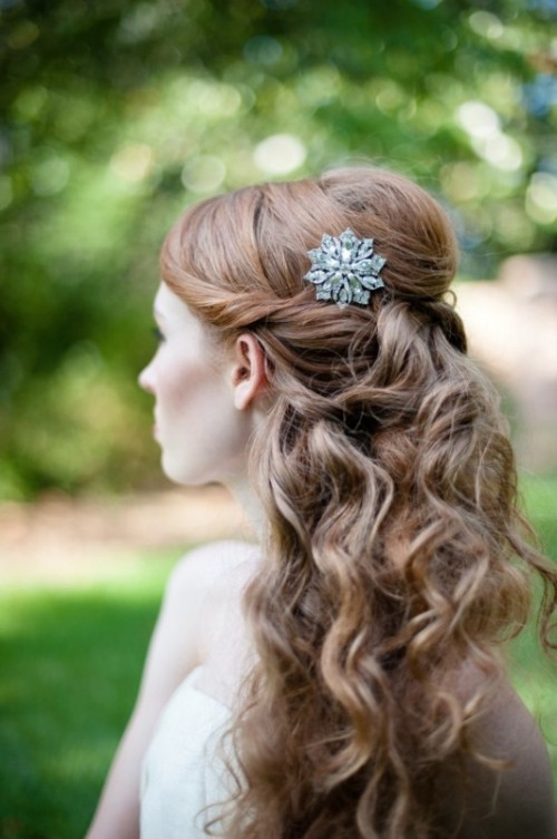 a vintage-inspired romantic wedding half updo with twists on the front, a volume on top and waves down plus an embellished hairpiece