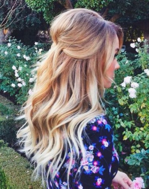 a chic and romantic wedding hairstyle with a volume on top, side bangs and waves down