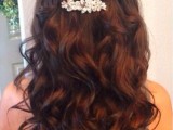 a refined vintage wedding hairstyle with a volume on top, twisted and braided halows plus waves going down to the shoulders