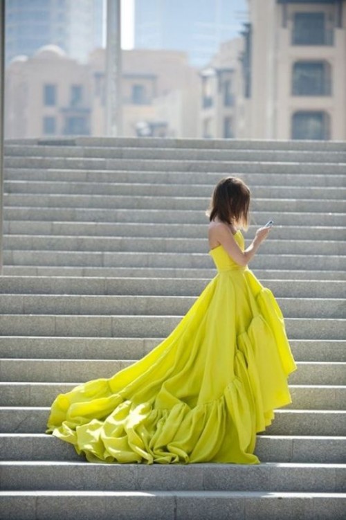 a strapless lemon-colored wedding ballgown with a high low skirt and a train is bold and very modern