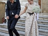 an off-white sheath wedding dress with polka dots, a high neckline and short sleeves plus a bow on the waist is very playful