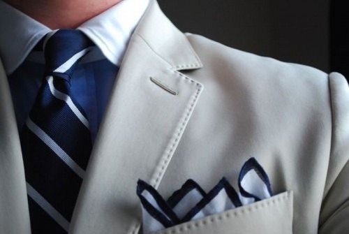 a groom's or groomsman look with a creamy jacket, a blue shirt, striped tie and handkerchief