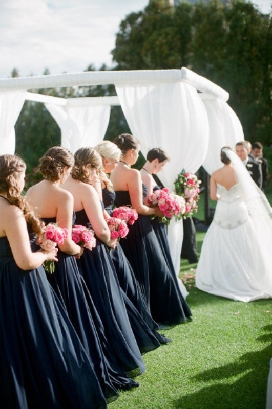Matching strapless midnight blue bridesmaid dresses and contrasting pink bouquet