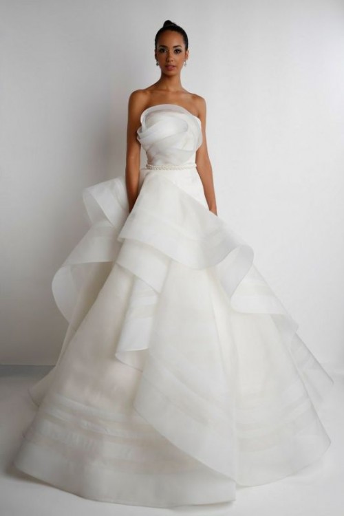 an edgy modern princess style wedding dress with a strapless bodice and ruffles and swirls of fabric for a sculptural shape