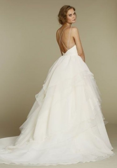 a modern princess style wedding dress with a plain bodice, thin straps crossed on the back and a layered tulle skirt with a train is a cool solution