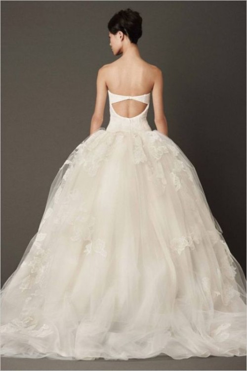 a modern and bold strapless princess style wedding dress with a cutout back, a lace applique full skirt with a train