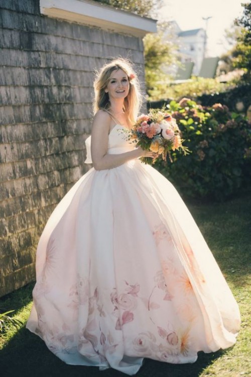 a romantic princess style wedding dress with a bodice on spaghetti straps, a fully skirt with floral print on the hem for a flower child bride