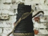a black textural wedding cake with gold lace is a cool moody wedding dessert to try