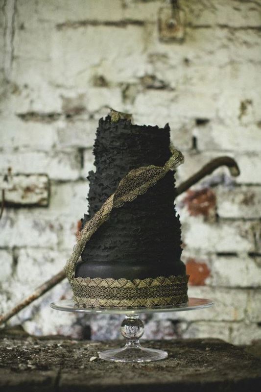 A black textural wedding cake with gold lace is a cool moody wedding dessert to try