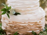 a ruffle wedding cake with an ombre tier decorated with eucalyptus looks romantic and elegant