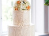 a white textural wedding cake with bright blooms on top is a cool idea for a modern wedding