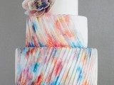 a colorful striped textural wedding cake with a large sugar flower is a bold idea for a modern wedding