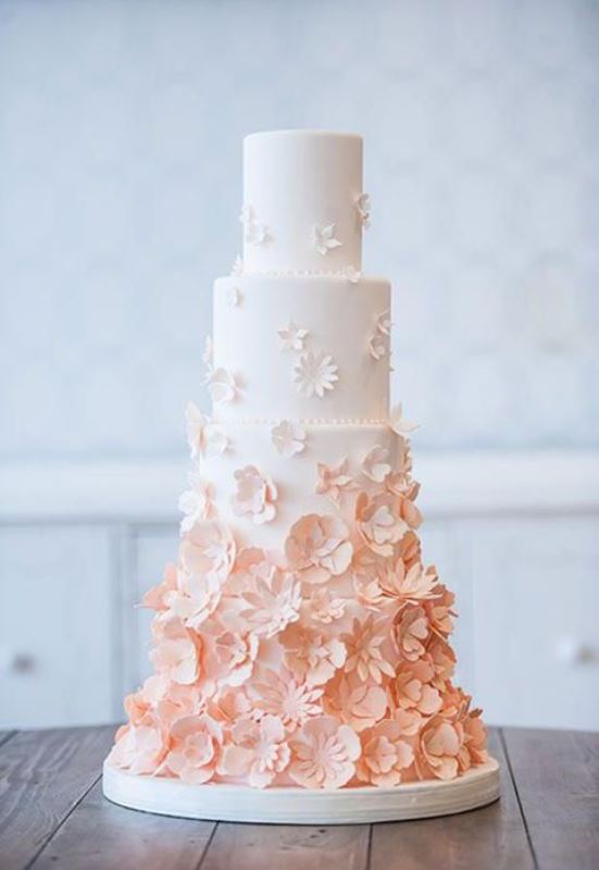 an ombre white to peachy wedding cake with lots of sugar blooms is very chic for spring or summer