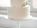 a white textural wedding cake with sugar blooms, leaves and berries is a cool and cute idea