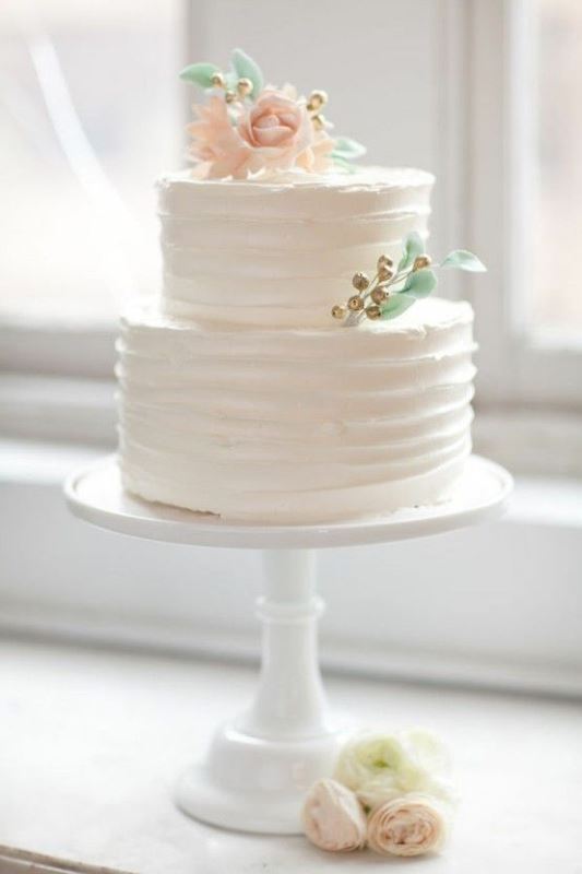 A white textural wedding cake with sugar blooms, leaves and berries is a cool and cute idea