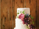 a white textural lace wedding cake with super bright blooms and leaves is a refined and romantic idea