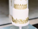 a white wedding cake with textural gold lace is a cool and fresh idea for a modern refined wedding