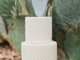 a white textural geometric wedding cake with a cactus on top for a modern or boho desert wedding