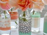 coral blooms in bottles wrapped with mint, coral and grey printed covers are amazing and simple wedding centerpieces
