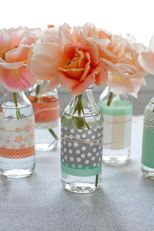 coral blooms in bottles wrapped with mint, coral and grey printed covers are amazing and simple wedding centerpieces