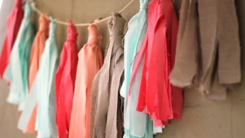 mint, coral and taupe wedding garland with tassels is a cool and creative idea for a wedding