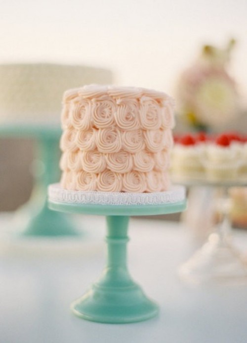 a creamy swirl wedding cake on a mint stand is a cool idea for cream, mint and coral wedding