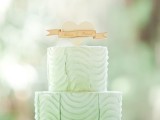 a pretty textural mint wedding cake with a white heart and a topper for a bold coral, mint and creamy wedding