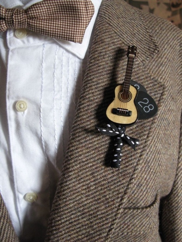 a creative guitar wedding boutonniere with a date and a bow is a perfect solution for a groom who loves music