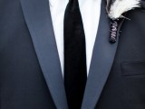 a feather wedding boutonniere with a black wrap will match a boho or Halloween groom style highlighting the time