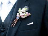 a wedding boutonniere of berries and feathers is a lovely idea for a modern groom who wants to add a bit of spice to his look