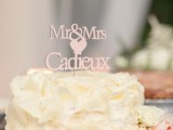 a wedding cake covered with creamy petals all over and with a lovely pink letter topper with a heart is a great idea for any wedding