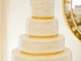 a white patterned wedding cake with yellow ribbon and a black silhouette cake topper is a lovely idea for a chic vintage wedding