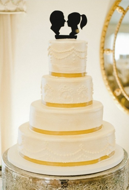 a white patterned wedding cake with yellow ribbon and a black silhouette cake topper is a lovely idea for a chic vintage wedding