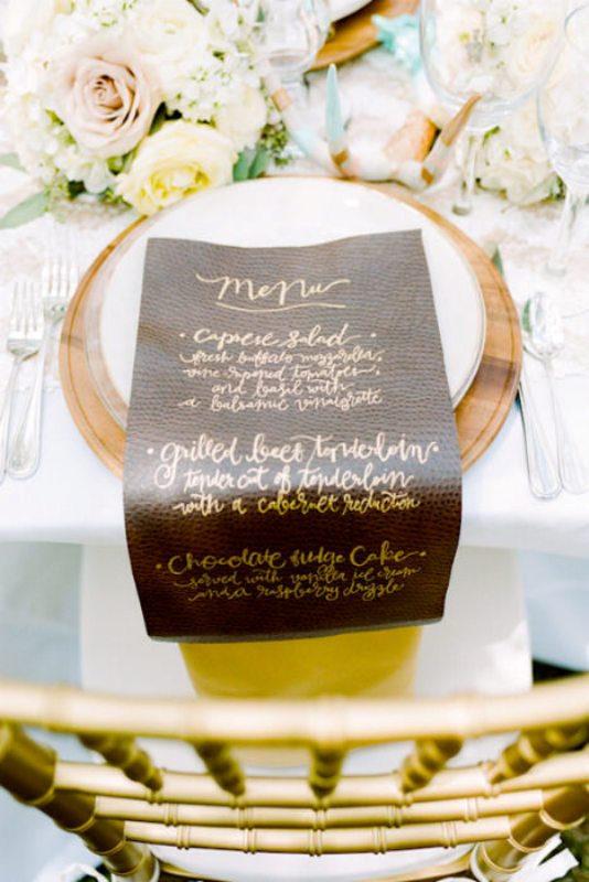 A faux leather menu with gold calligraphy will give a textural look and a refined touch to the space